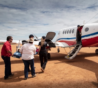 Royal Flying Doctor Service aircraft and medical staff transporting a patient